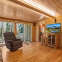 Welcome to a cozy retreat featuring natural wood finishes and two sliders for abundant light.