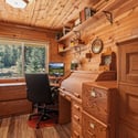 Cozy office space featuring natural wood accents, ample storage, and picturesque views of surrounding nature.