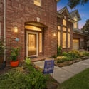 Stunning brick façade home featuring vibrant landscaping and abundant natural light, perfect for modern living.
