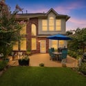 Enjoy outdoor living in this inviting backyard, featuring a shaded patio and vibrant garden elements.