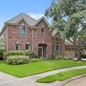 This spacious brick home features a beautifully landscaped yard and welcoming curb appeal, ideal for family living.
