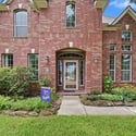 Inviting brick home with spacious front yard, large windows, and welcoming entrance near local amenities.