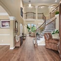 Spacious entryway features a dual staircase and open layout, perfect for welcoming gatherings and family activities.