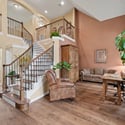Welcoming entryway with a grand staircase, ample natural light, and flexible spaces for living and working.