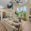 Spacious living area features high ceilings, abundant natural light, and a cozy fireplace for gatherings.
