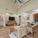 Spacious living area with high ceilings, a cozy fireplace, and abundant natural light throughout.