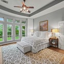 Spacious bedroom featuring large windows, lush views, and a cozy sitting area for relaxation.
