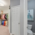 Spacious walk-in closet seamlessly connects to a convenient half-bath, ideal for modern living arrangements.