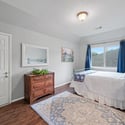 Bright and inviting bedroom featuring large windows, modern decor, and ample natural light throughout.