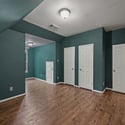 Spacious room with unique angles, featuring durable floors and ample storage options throughout.