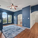 Spacious room featuring bold blue walls, ample natural light, and unique architectural details, perfect for versatile use.