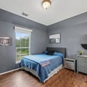 Spacious bedroom featuring contemporary decor, large windows, and ample natural light for a welcoming atmosphere.