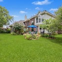 Spacious backyard with lush greenery and inviting patio, perfect for outdoor gatherings and relaxation.