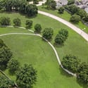 Spacious green park area features winding paths, mature trees, and convenient access to nearby residential neighborhoods.