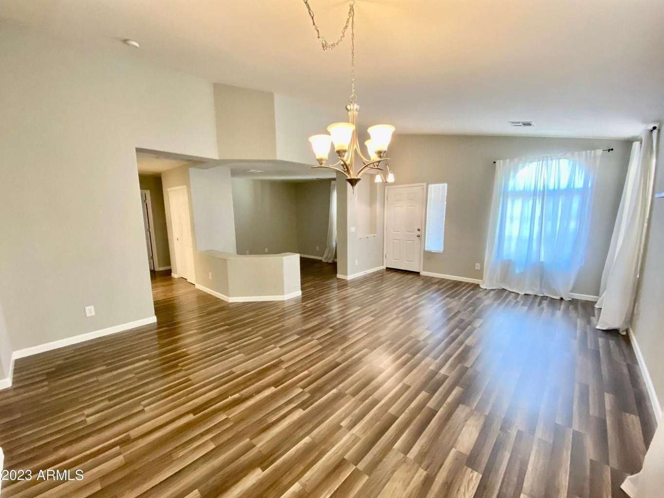 3 of 16. Open and airy great room featuring updated flooring, soaring natural light, and flexible living space. Perfect for entertaining guests or enjoying everyday comfort.