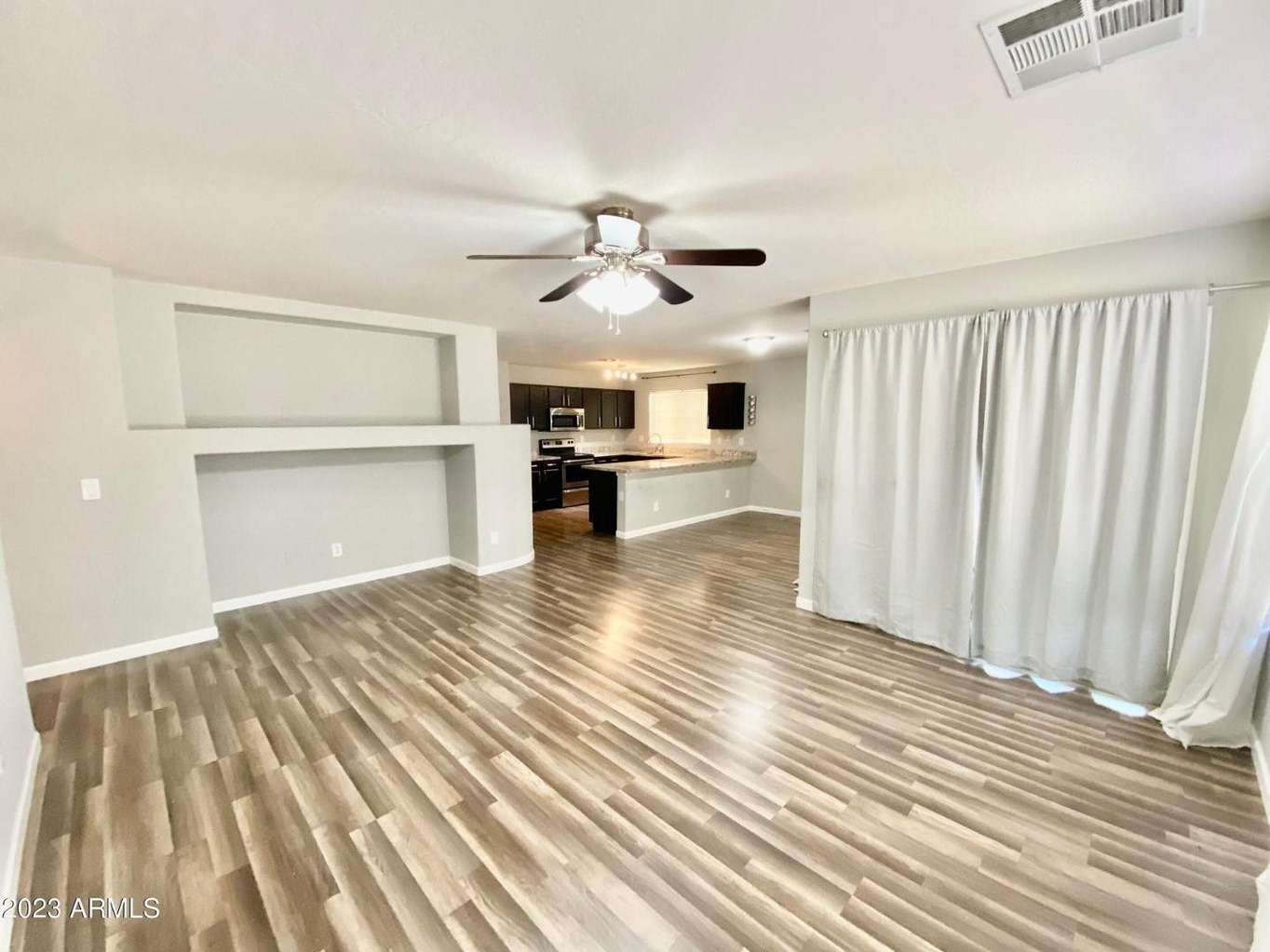 7 of 16. Comfortable living area with durable flooring, neutral finishes, and open sightlines throughout the main living spaces. Perfect for relaxing or hosting friends and family.