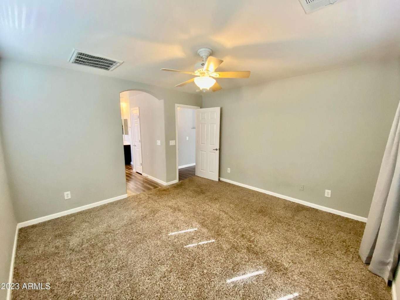 10 of 16. Comfortable owner's suite featuring generous dimensions, natural light, and soft carpeting. The split-bedroom layout enhances privacy and functionality throughout the home.