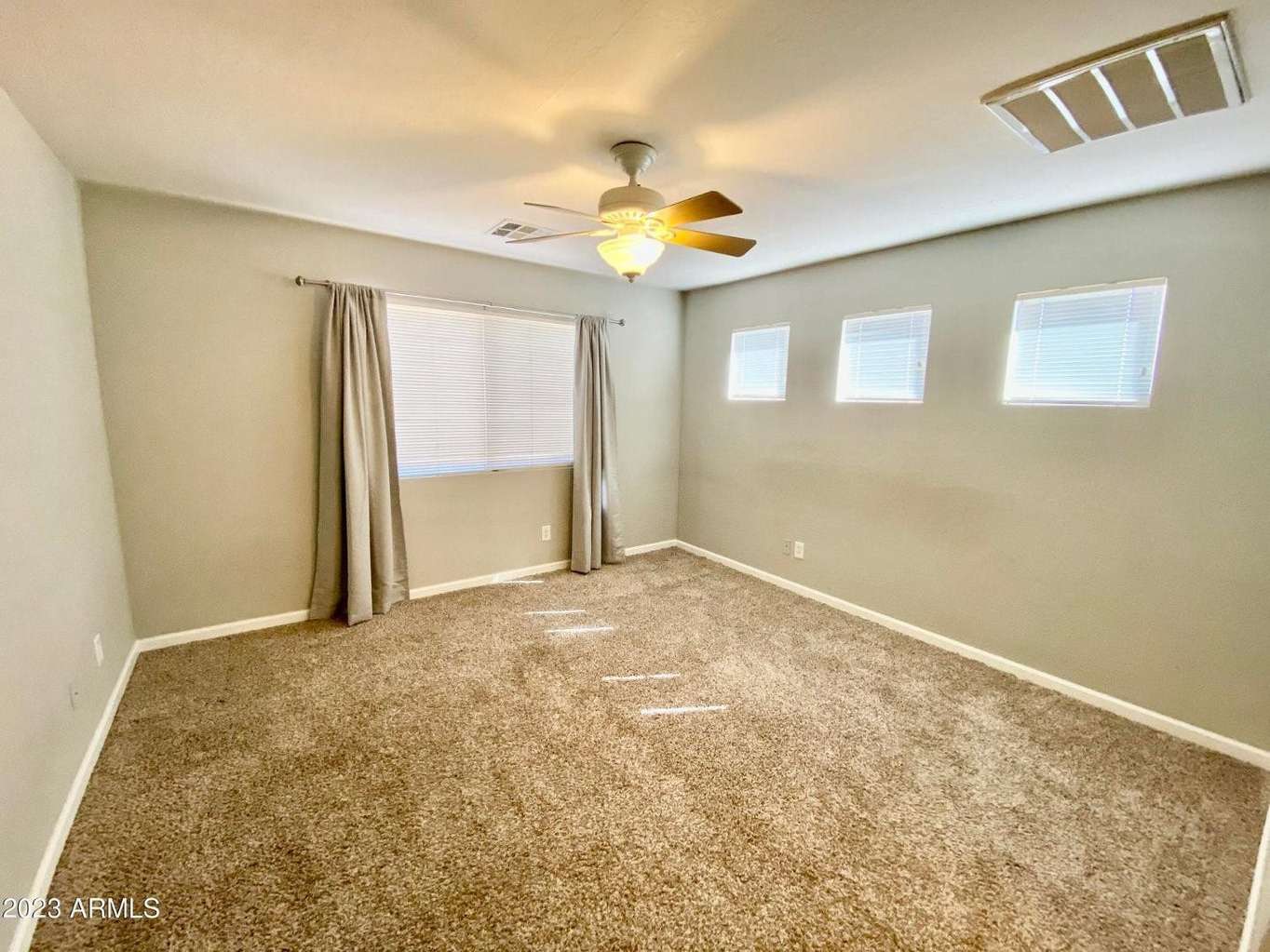 11 of 16. Inviting secondary bedroom offering soft carpeting, neutral finishes, ceiling fan comfort, and natural light. A flexible space perfect for guests, family, or remote work needs.