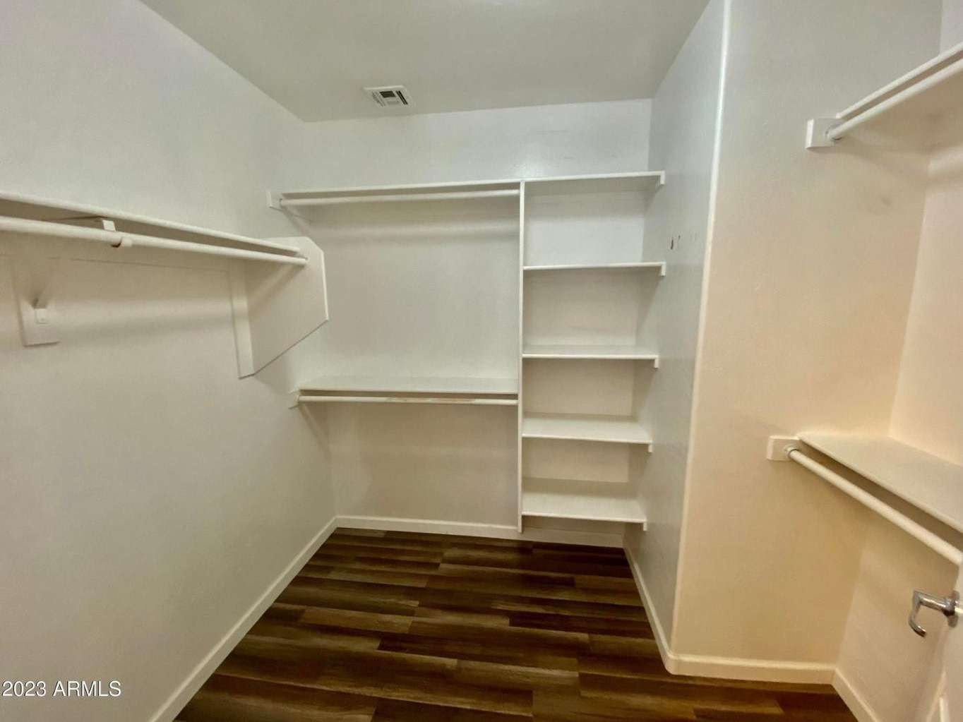 15 of 16. Walk-in closet featuring extensive shelving, hanging space, and room for seasonal storage. An excellent feature that adds organization and value to this Surprise home.