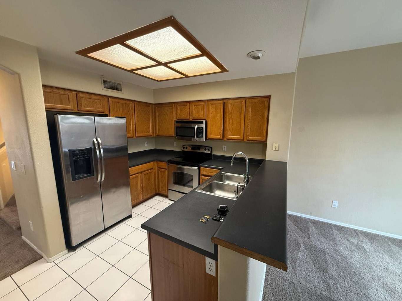 10 of 22. Open kitchen design with stainless steel appliances, breakfast bar seating, and easy access to the surrounding living spaces. Ideal for both entertaining and everyday use.