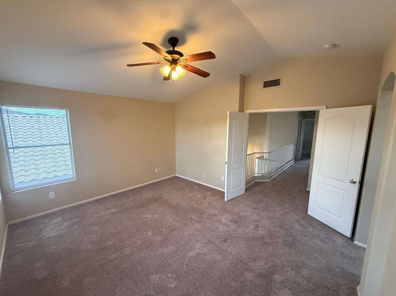 13 of 22. Spacious primary bedroom offering plush carpeting, ceiling fan, and abundant natural light. The generous layout provides flexibility for additional seating or workspace arrangements.