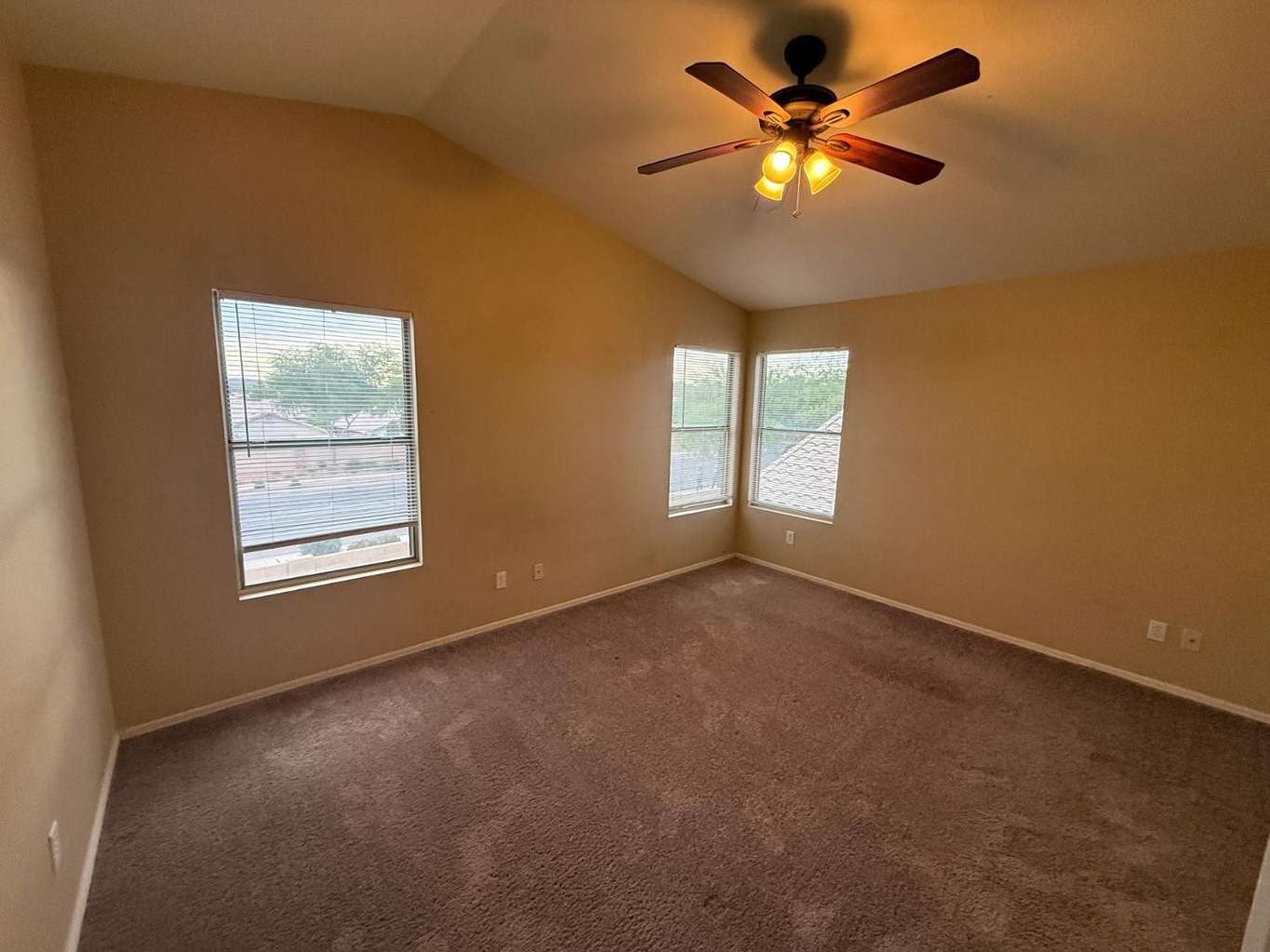 14 of 22. Light-filled bedroom featuring vaulted ceilings, multiple windows, and comfortable living space. A welcoming room with versatile use and attractive architectural character.