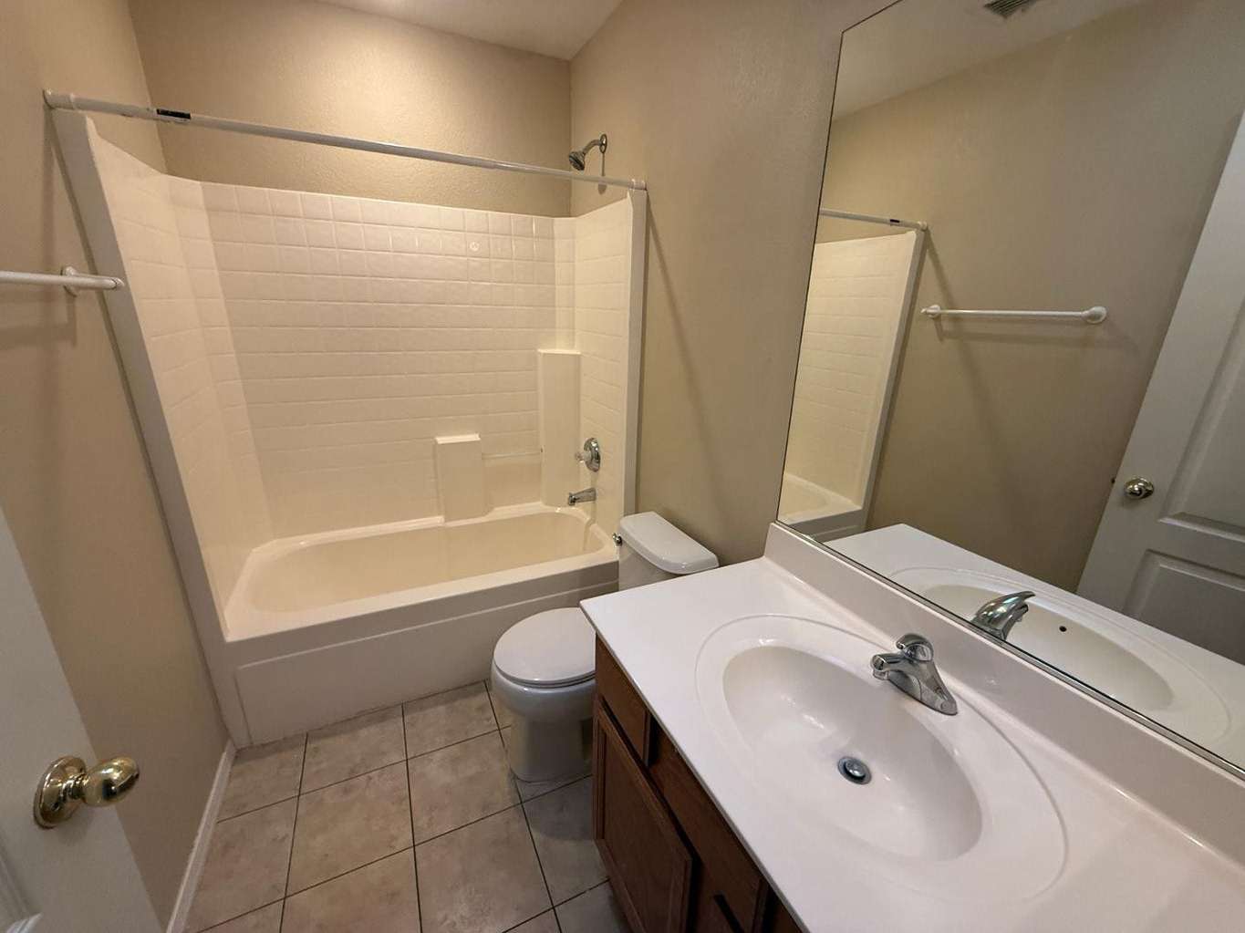 15 of 22. Full bathroom with combination tub and shower, large vanity mirror, tile flooring, and practical storage. Neutral finishes create a timeless and move-in-ready appearance.