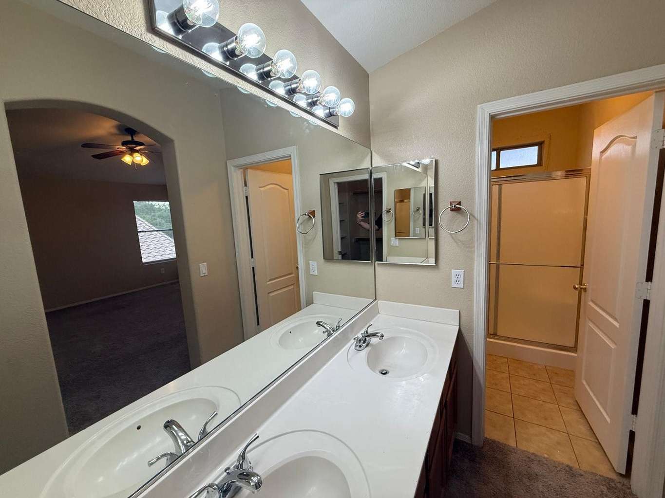 18 of 22. Spacious primary bathroom showcasing dual vanities, expansive mirrors, and convenient access to the shower area. Ideal for busy mornings and shared routines.