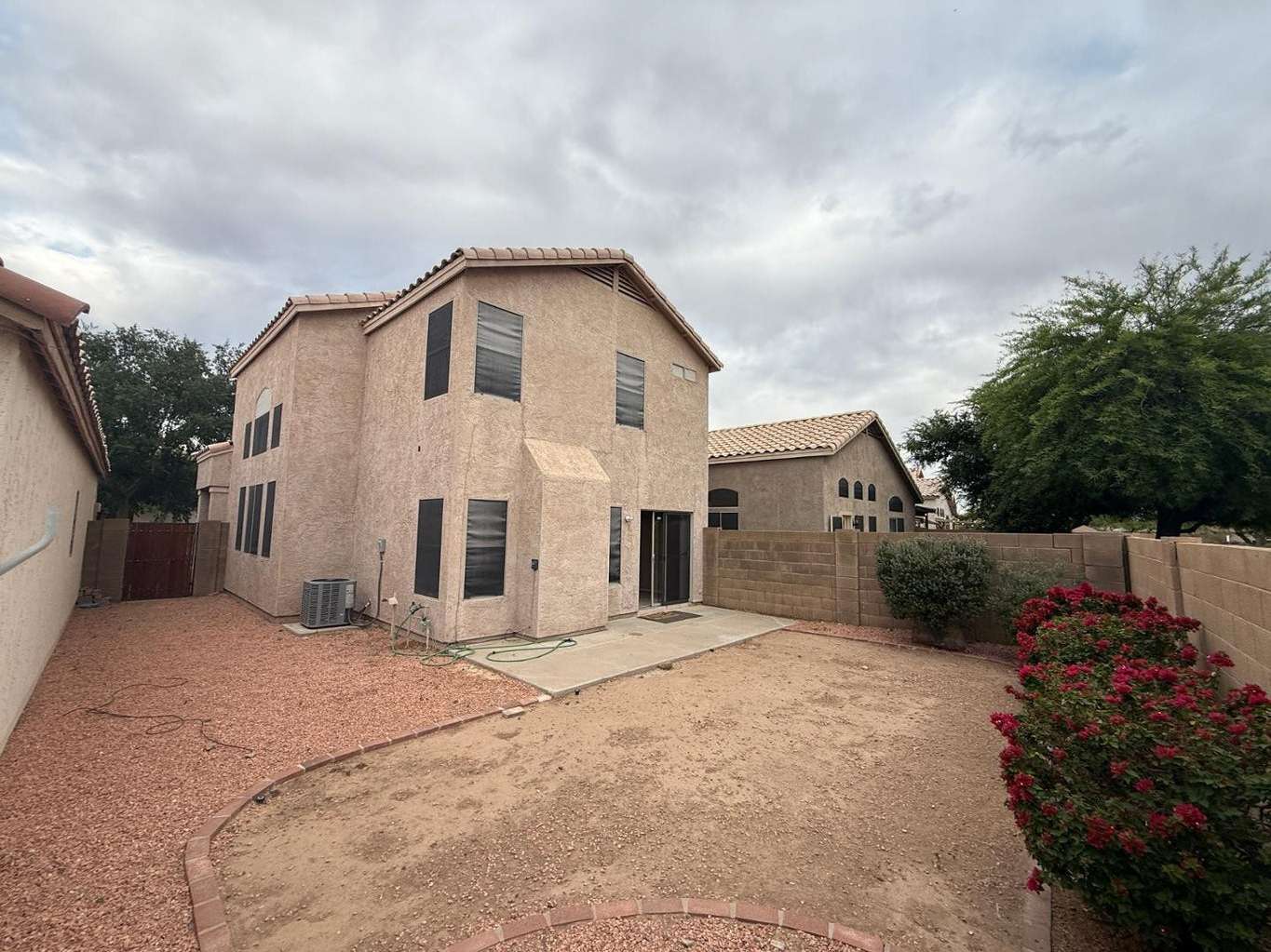 22 of 22. Exterior rear view highlighting the home's private backyard, concrete patio, and low-maintenance landscaping. Designed for easy outdoor living, this space offers privacy, functionality, and room to enjoy Glendale's outdoor lifestyle.