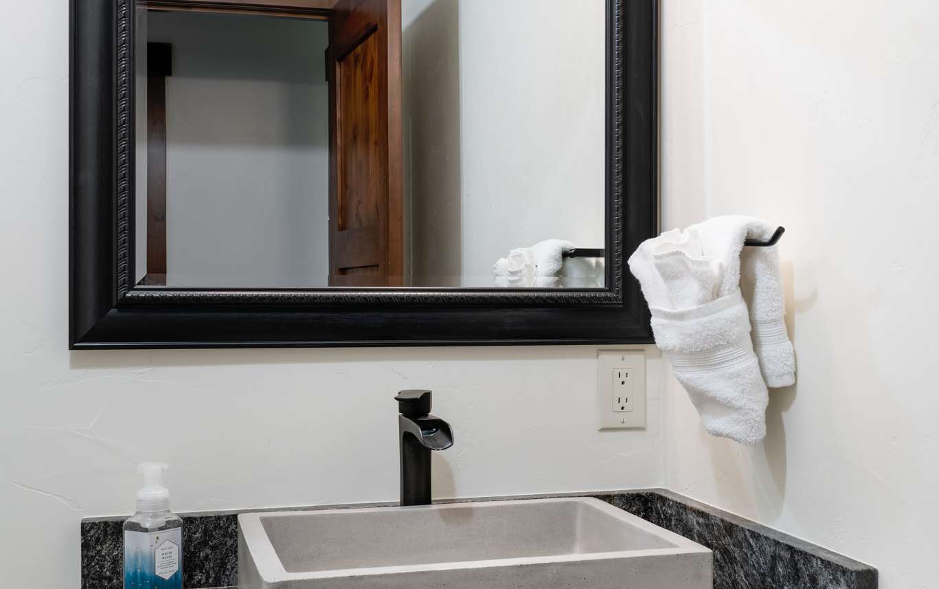 32 of 42. Lower-level powder room bath featuring a sleek countertop, minimalist sink, and ample natural light, perfect for daily routines.