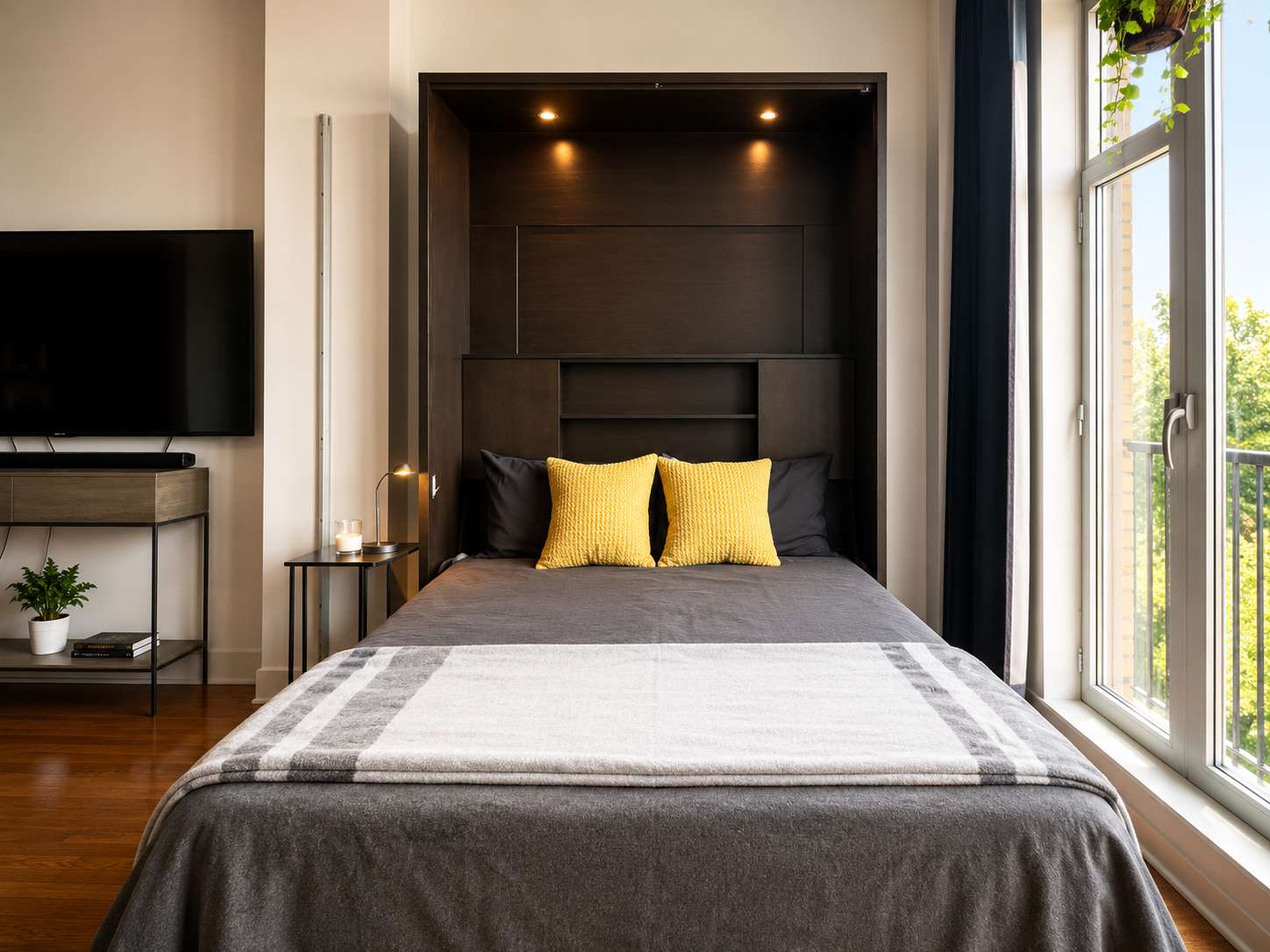 14 of 21. Bright and cozy bedroom featuring a modern foldaway bed and large windows bringing in natural light.