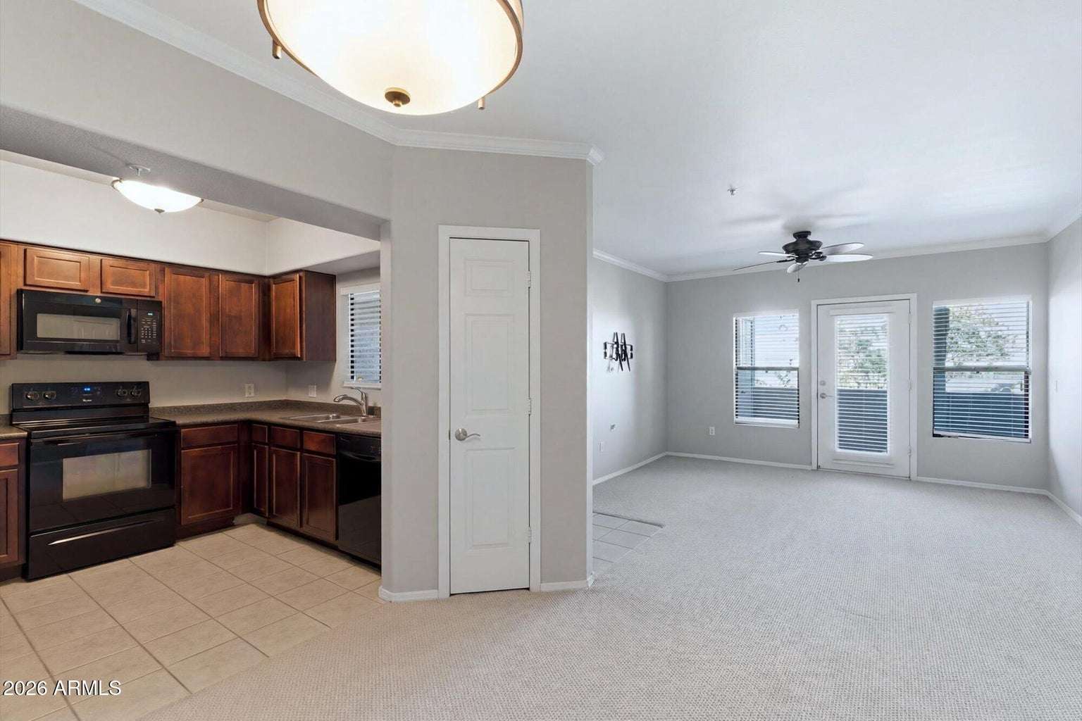 11 of 32. Enjoy an open-concept design where the kitchen flows effortlessly into the spacious living room with private balcony access. Rich wood cabinetry, updated appliances, and neutral finishes create a welcoming Scottsdale home.