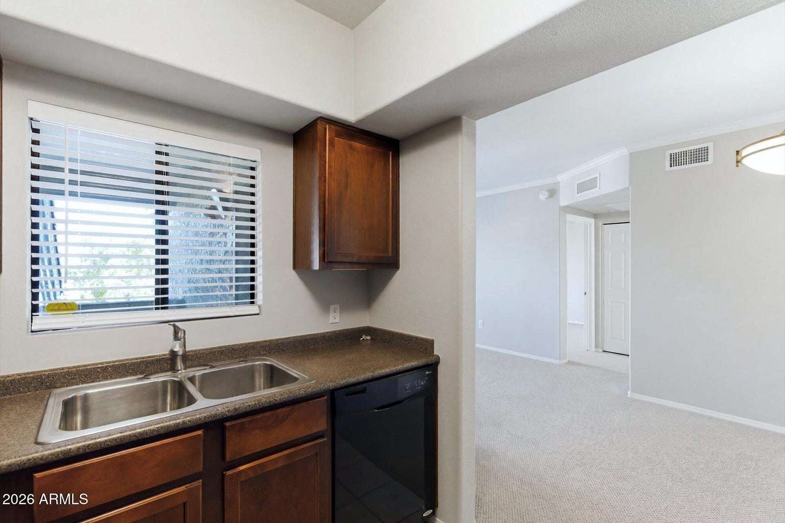 15 of 32. The kitchen opens directly to the living area, allowing natural light to flow throughout the home. Rich cabinetry, ample workspace, and updated appliances enhance both convenience and comfort.