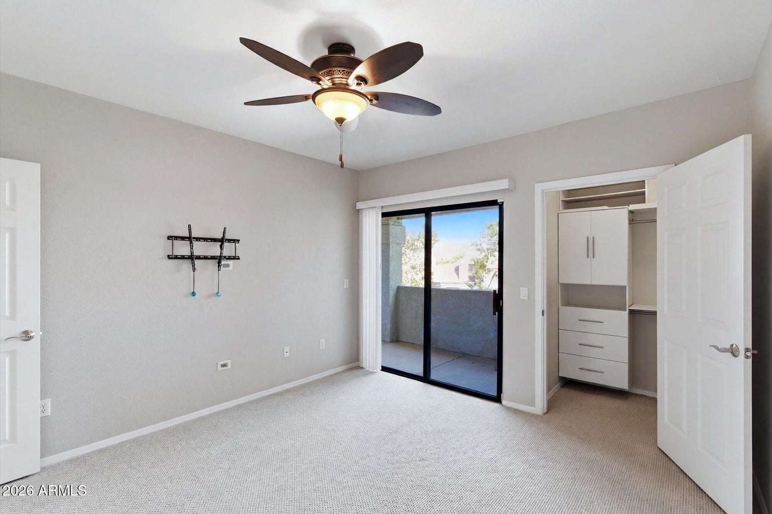 18 of 32. Enjoy direct balcony access from the primary bedroom along with a spacious walk-in closet featuring built-in drawers and shelving. Natural light and neutral d cor make this room warm and inviting.