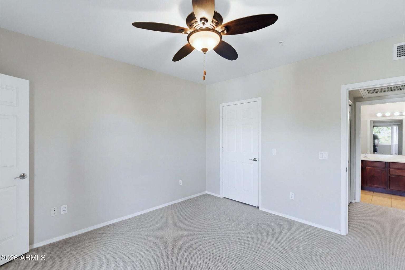 19 of 32. The generous owner's suite features plush carpeting, ceiling fan, neutral finishes, and convenient access to the adjoining bathroom, creating a peaceful and functional living space.