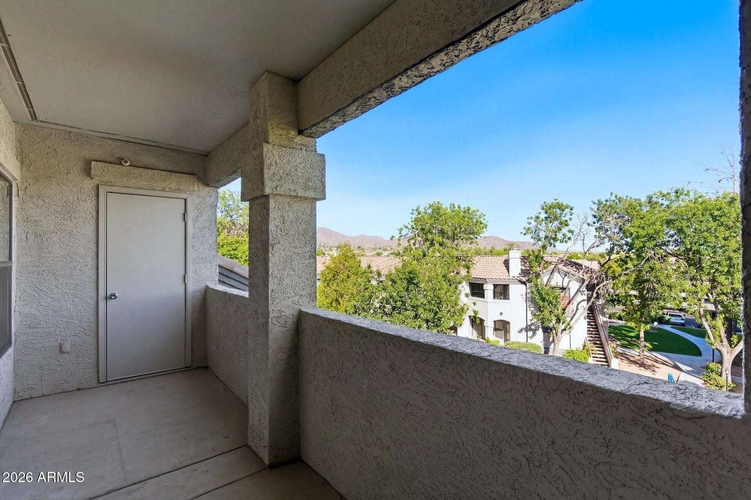 23 of 32. This spacious covered balcony offers relaxing outdoor living with beautiful mountain views, mature trees, and attractive community landscaping, making it the perfect extension of the home's living space.