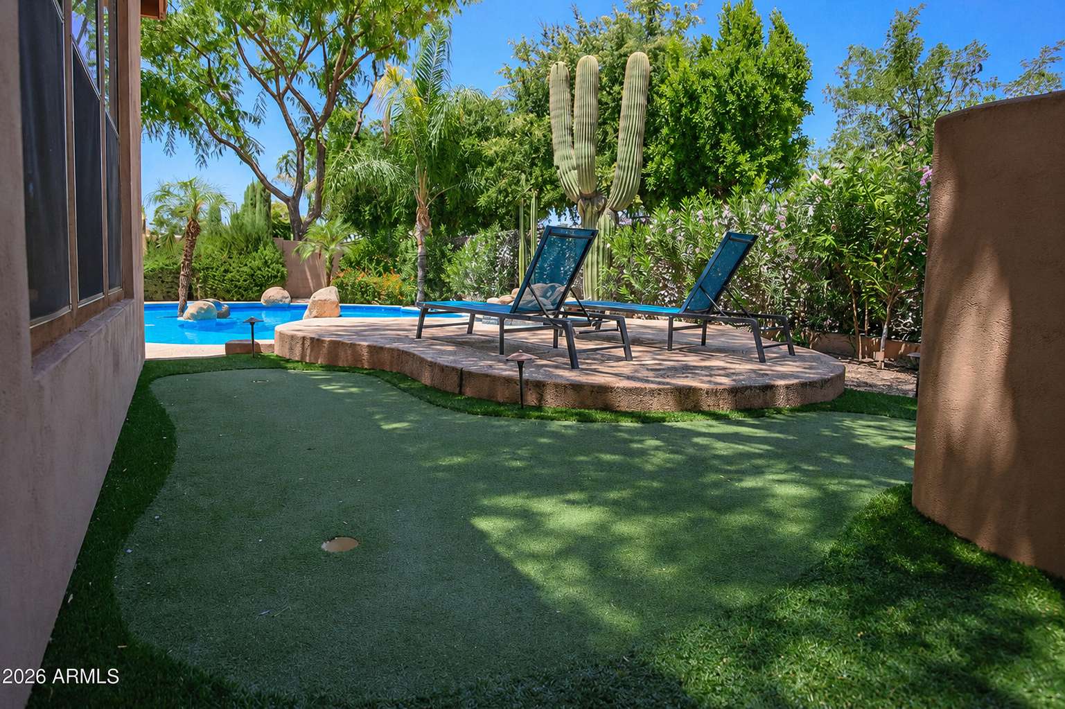 66 of 72. Enjoy comfortable outdoor gatherings beneath the spacious covered patio complete with ceiling fan, conversation seating, and easy access to the custom pool and backyard retreat.