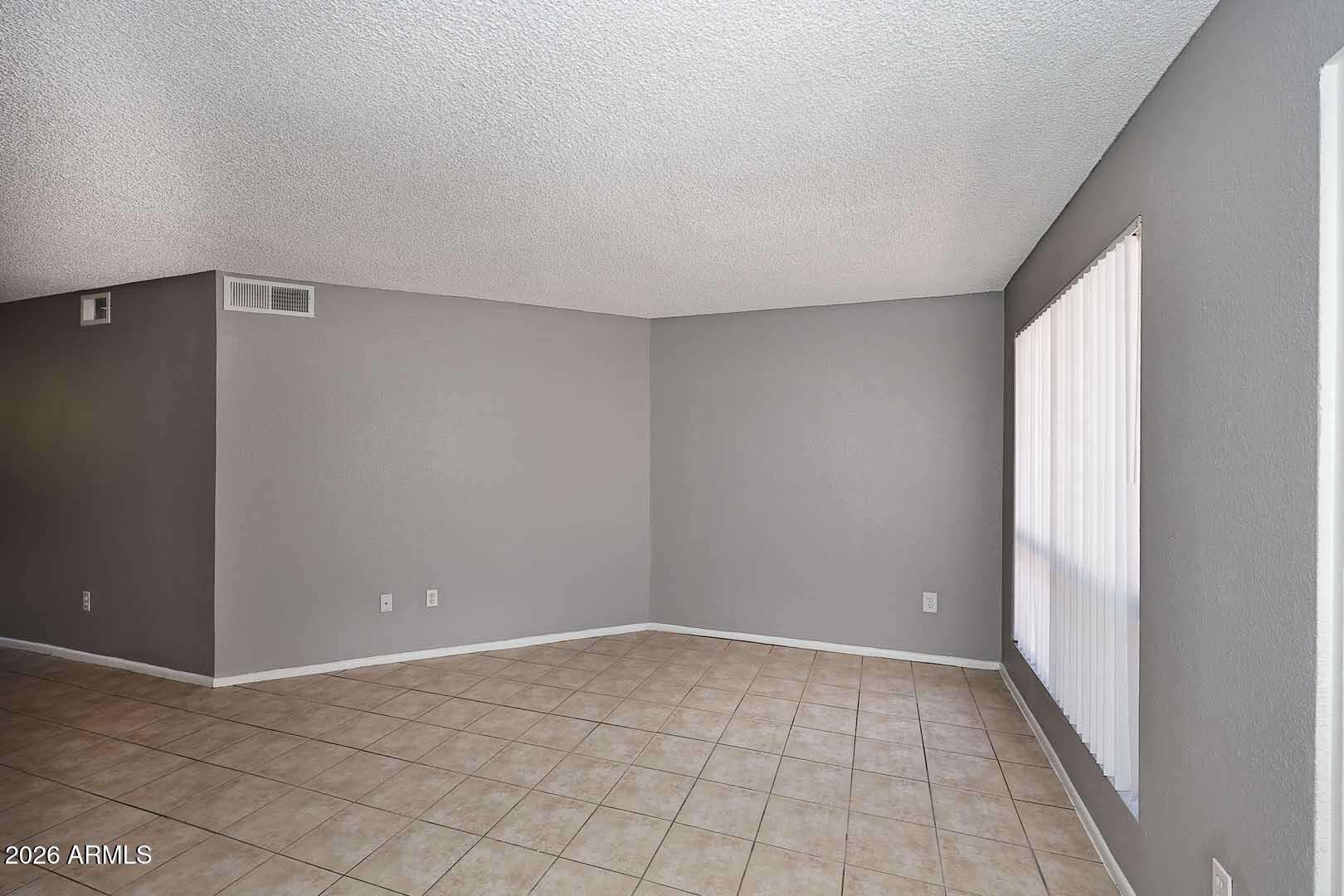 7 of 29. Large great room with clean lines, neutral d cor, and tile flooring throughout. The flexible floor plan accommodates a variety of furniture arrangements and lifestyle needs.