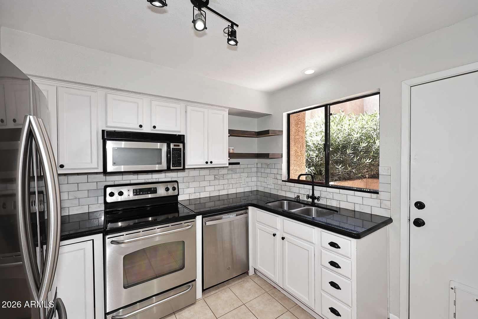 10 of 29. Updated kitchen featuring stainless steel appliances, subway tile backsplash, refreshed cabinetry, and abundant workspace. Designed to blend style, storage, and functionality for daily living.