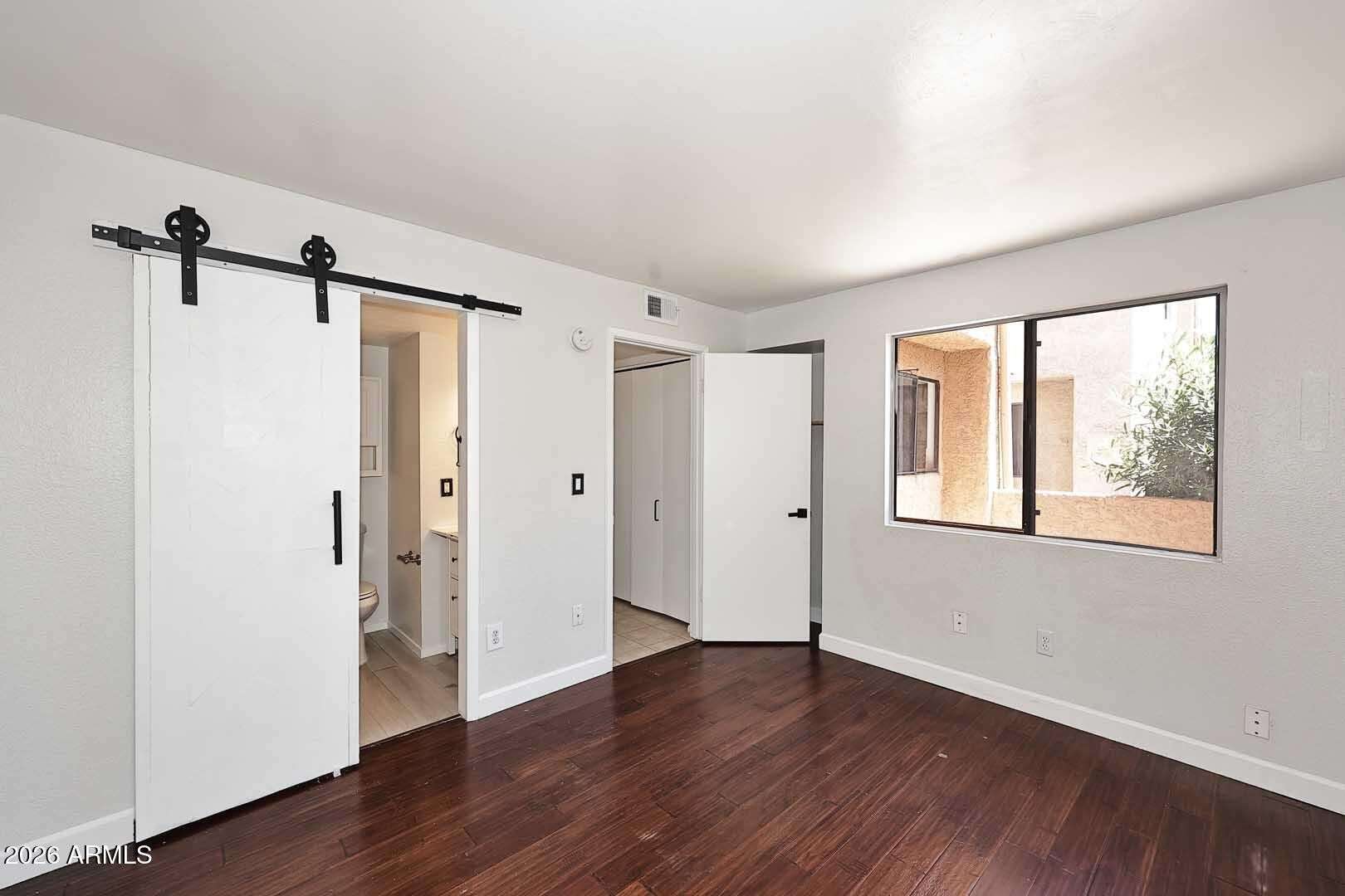 13 of 29. Spacious primary suite offering updated flooring, neutral tones, and convenient access to the ensuite bathroom. A comfortable and inviting space designed for relaxation.