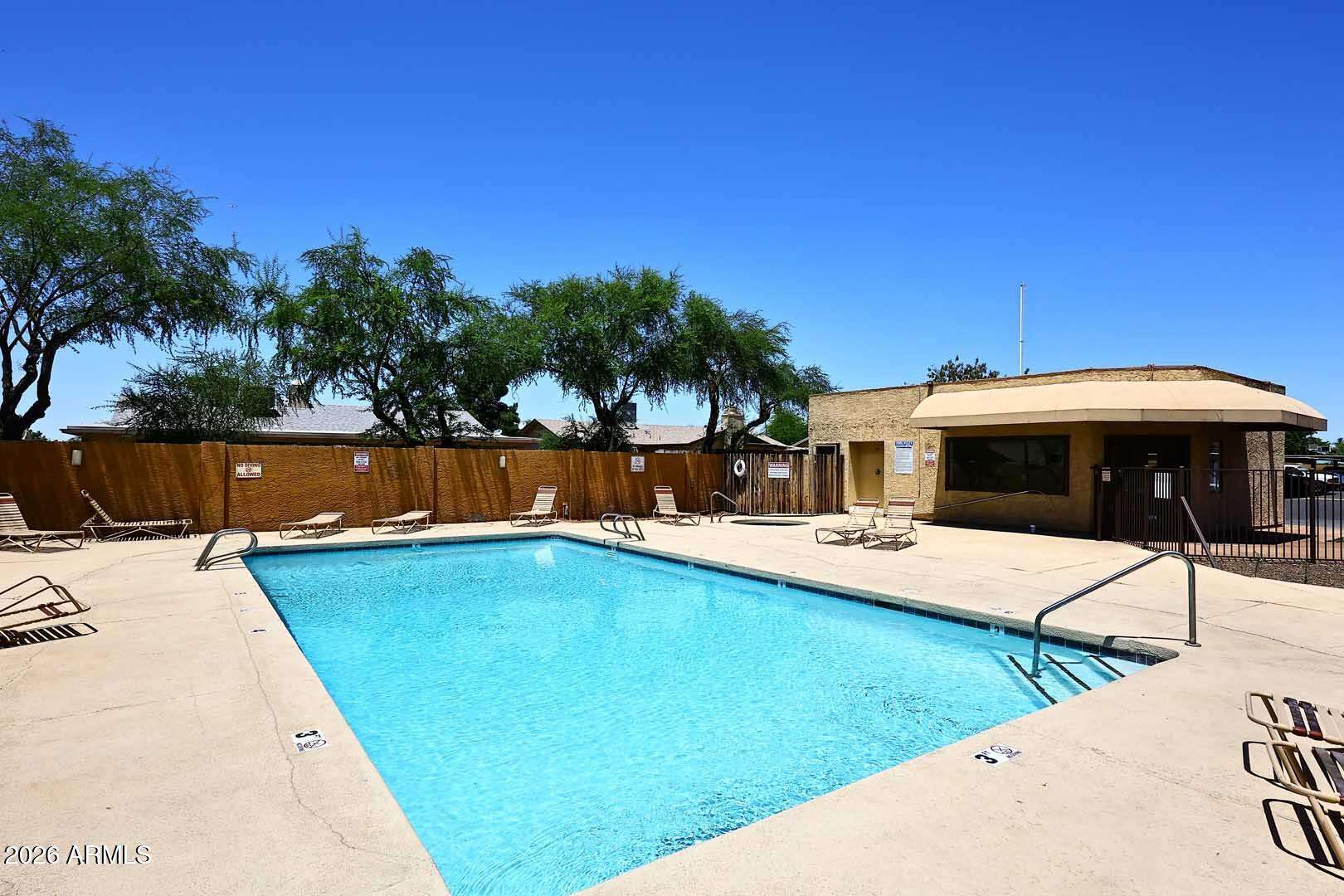 26 of 29. Community recreation area featuring a sparkling swimming pool, relaxing spa, and ample deck space. Residents enjoy convenient access to resort-style amenities year-round.