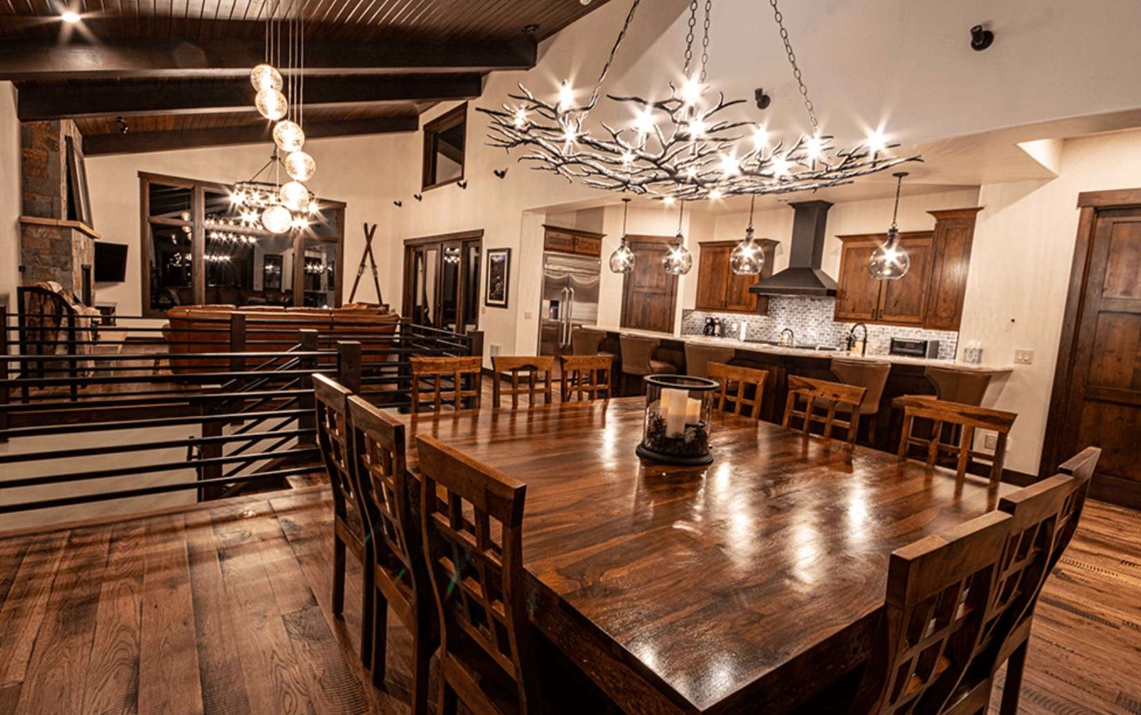 13 of 42. Spacious dining area featuring a striking chandelier, warm wood accents, and open layout perfect for gatherings.