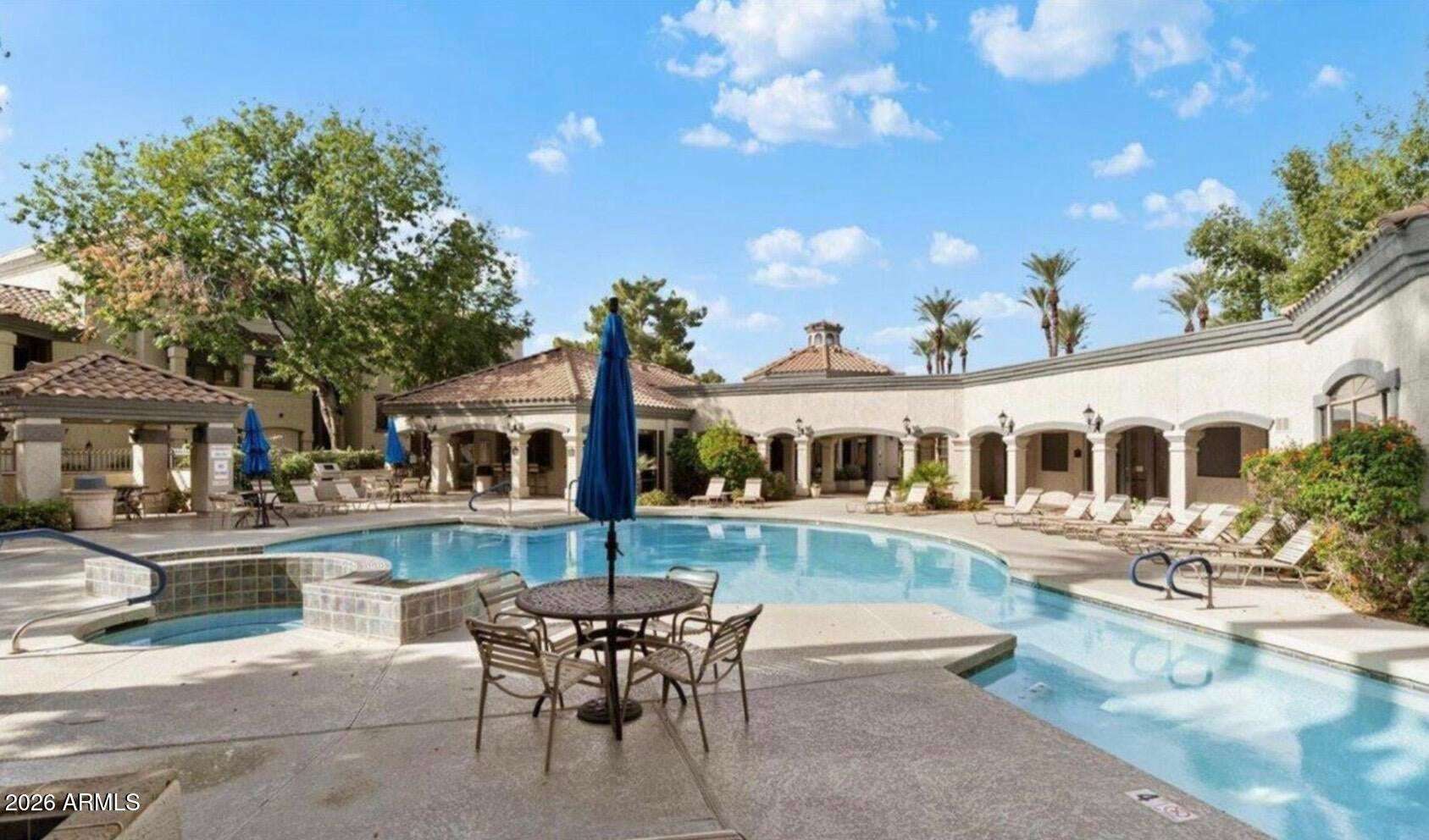 30 of 32. Experience resort-style amenities including a sparkling swimming pool, spa, shaded seating areas, and beautifully landscaped gathering spaces designed for relaxation and recreation in Scottsdale.