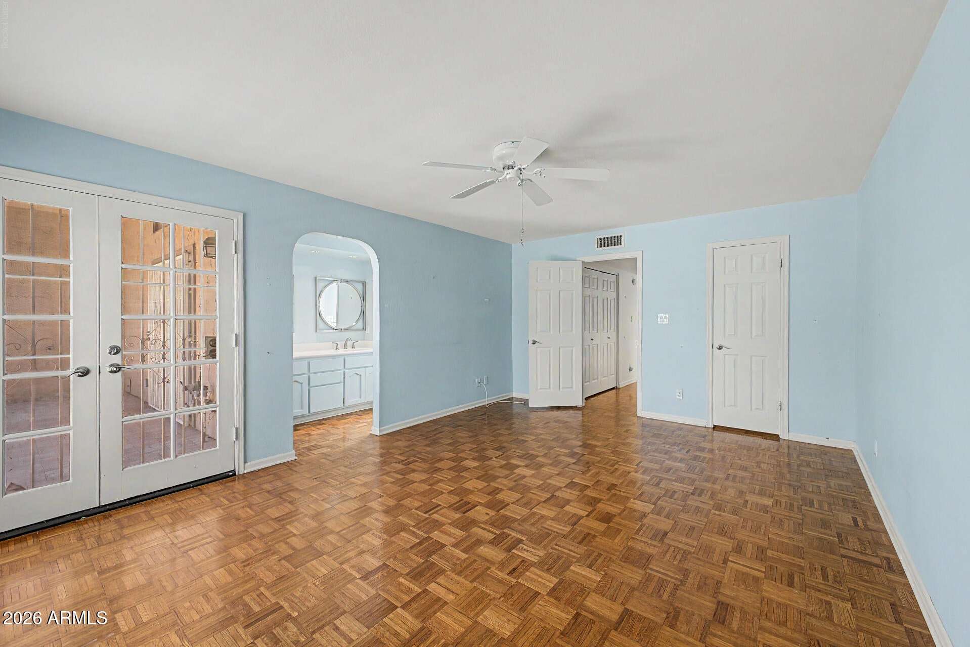 14 of 30. Comfortable owner's suite featuring direct access to outdoor living spaces, plantation shutters, and a connected vanity area. The layout enhances both privacy and convenience.