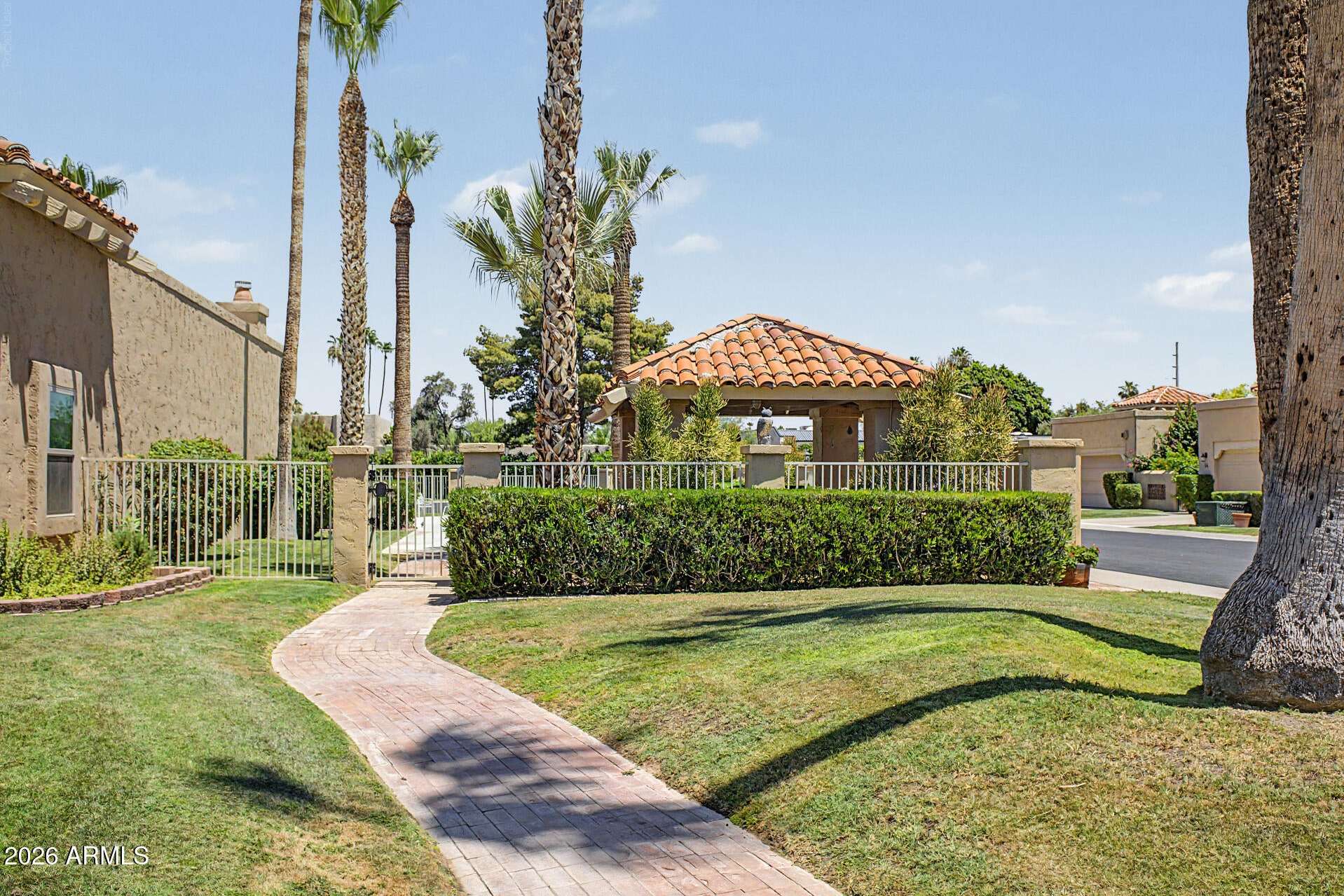 28 of 30. Attractive community common area featuring manicured lawns, mature palm trees, and charming pathways. Residents enjoy beautifully maintained surroundings within this Scottsdale neighborhood.