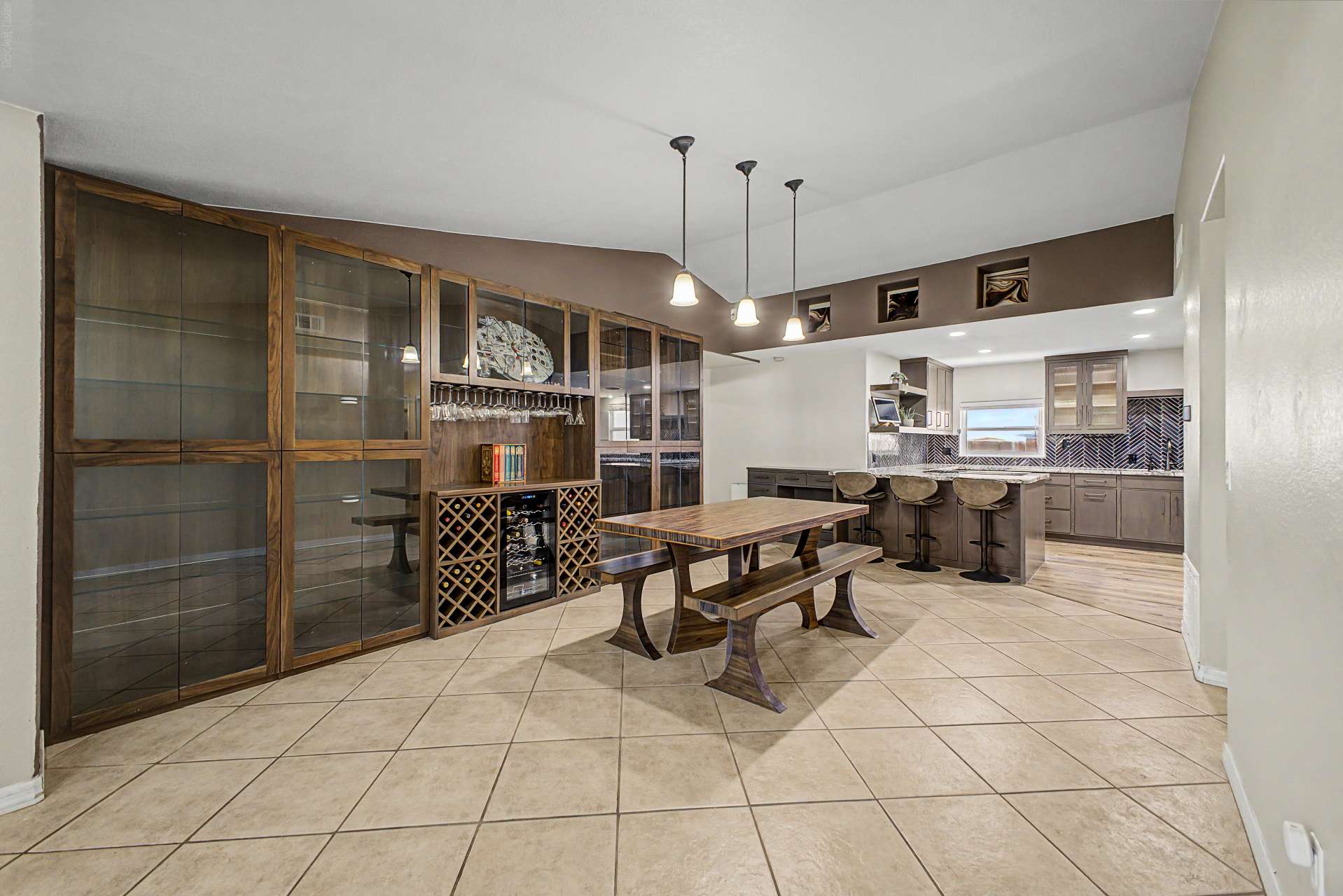 25 of 47. Gather in this elegant dining area featuring a custom built-in display cabinet with glass doors, wine storage, beverage refrigerator, and seamless access to the remodeled kitchen for effortless entertaining.