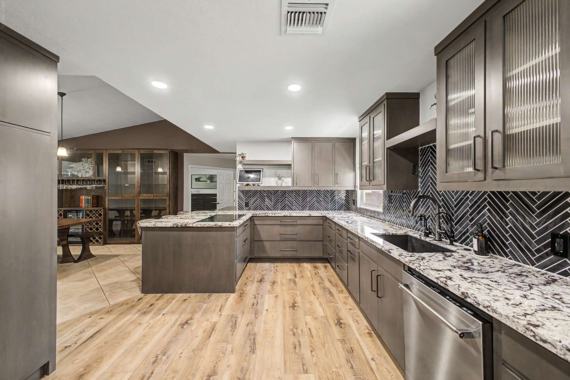 28 of 47. Beautiful cabinetry, designer tile backsplash, granite surfaces, recessed lighting, and generous workspace create a warm, inviting kitchen that's perfect for everyday living and hosting gatherings.