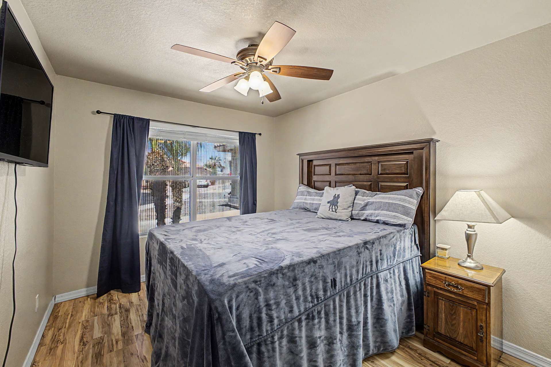 35 of 47. Featuring wood-look flooring, a large window, ceiling fan, and neutral d cor, this comfortable bedroom provides flexible living options for guests, family members, or remote work.