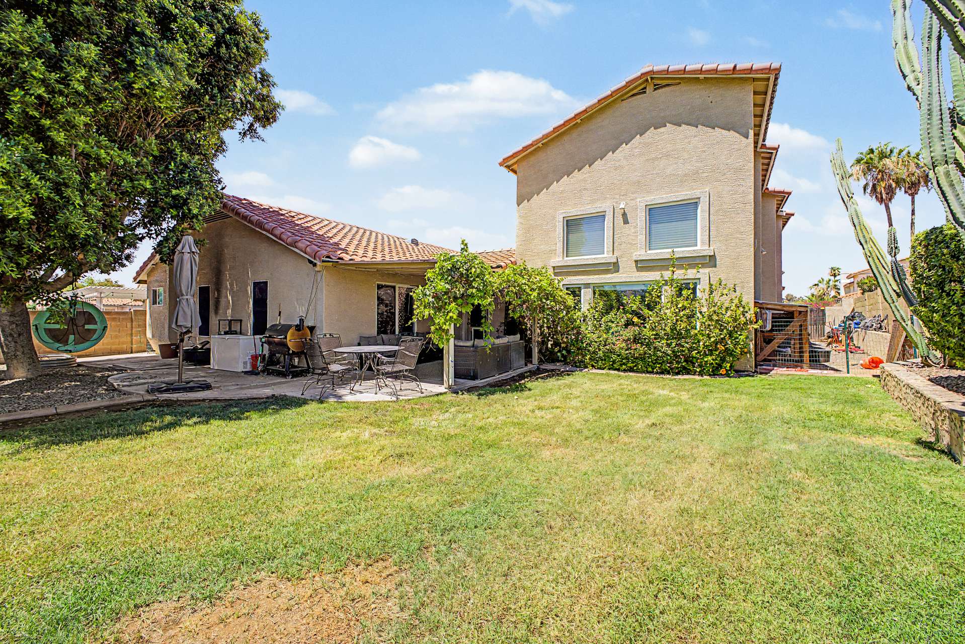 45 of 47. A spacious backyard with a large grassy area, mature trees, covered entertaining patio, and attractive landscaping provides the perfect outdoor environment for relaxing or hosting family and friends in Glendale.