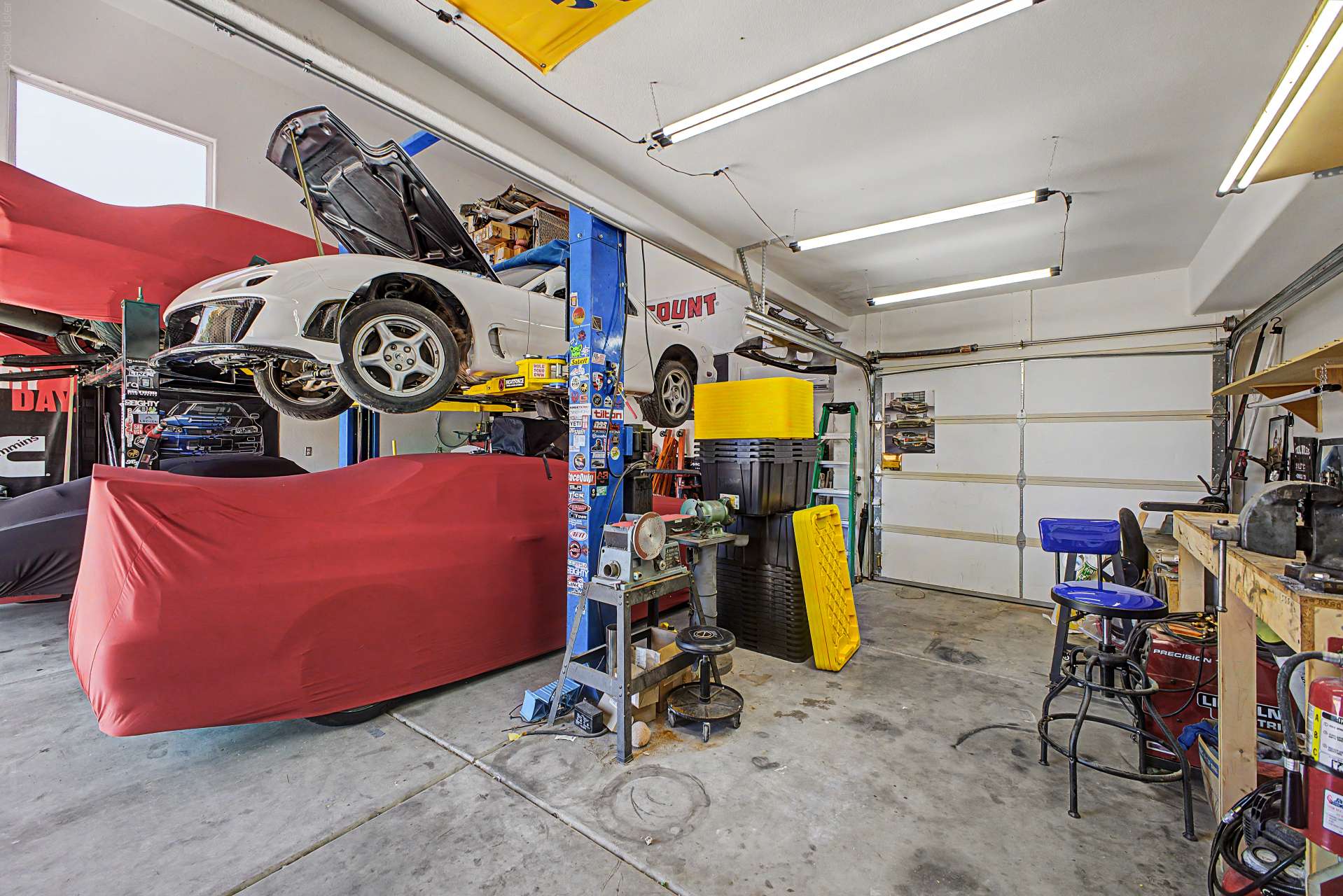 18 of 47. Exceptional garage space with approximately 20-foot ceilings offers endless possibilities for vehicle storage, restoration projects, workshop activities, or oversized equipment while maintaining outstanding organization.